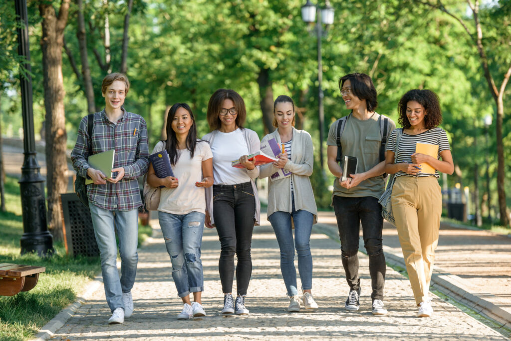 young-happy-students-walking-while-talking-looking-aside