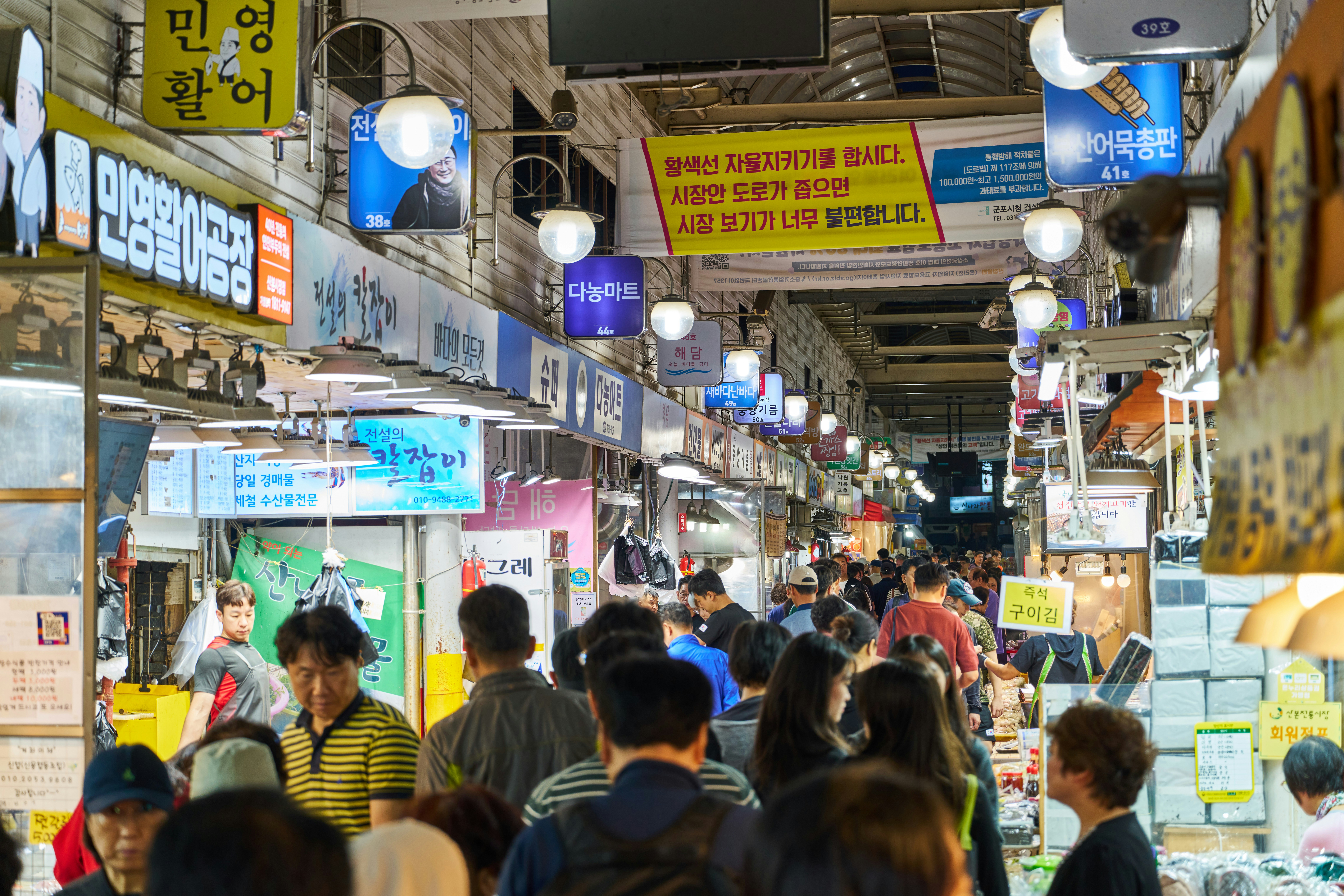 Pasar tradisional Korea Selatan yang dipenuhi dengan kios makanan dan penjual snack lokal